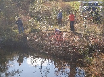 Island Waters Fly Fishers volunteers installing bioengineered fencing for bank stabilization along the Millstone River in 2019
